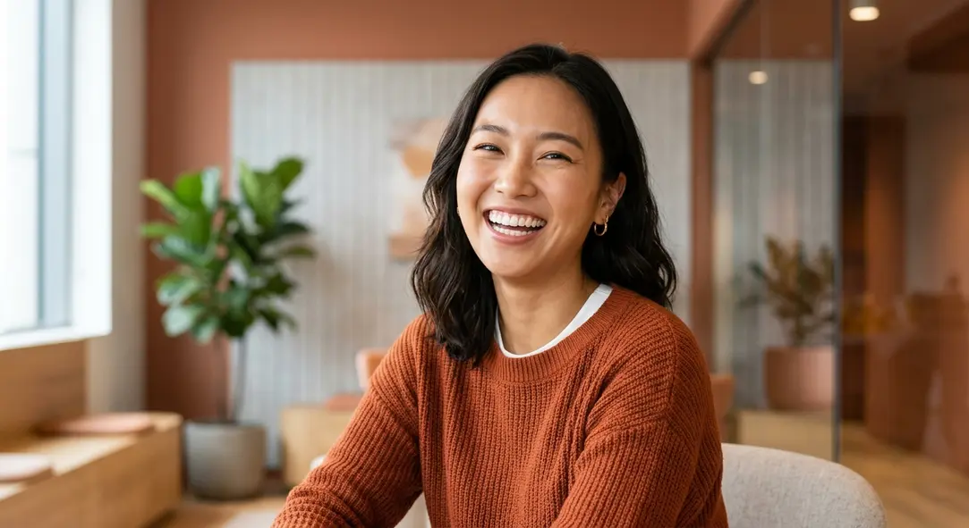 A joyful, confident woman smiling broadly, showcasing perfectly balanced teeth and healthy gums.