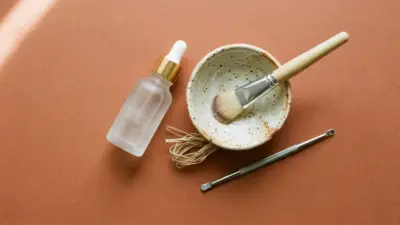A flat lay of professional skincare clinic tools on a warm terracotta background.