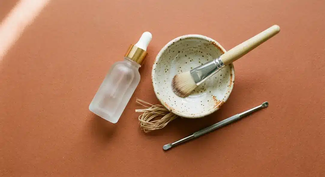 A flat lay of professional skincare clinic tools on a warm terracotta background.
