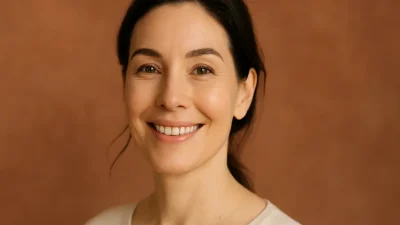 眉リフトを受けて、目元がパッチリとし、自信に満ちた笑顔を見せる30代後半から40代の女性の顔のクローズアップ。