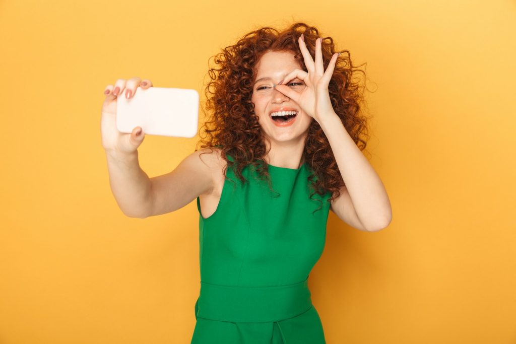 a woman in a green dress holding a white object